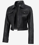 Angled front view of Elara women's black cropped leather trucker jacket with a front zip and flap chest pockets