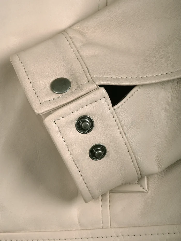 Close-up of cuff and button detailing on beige leather Harrington jacket | NSM Jackets