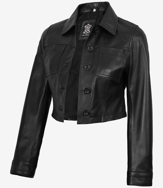 Angled front view of Mila women's black cropped leather trucker jacket showing the button fastening and cropped hem