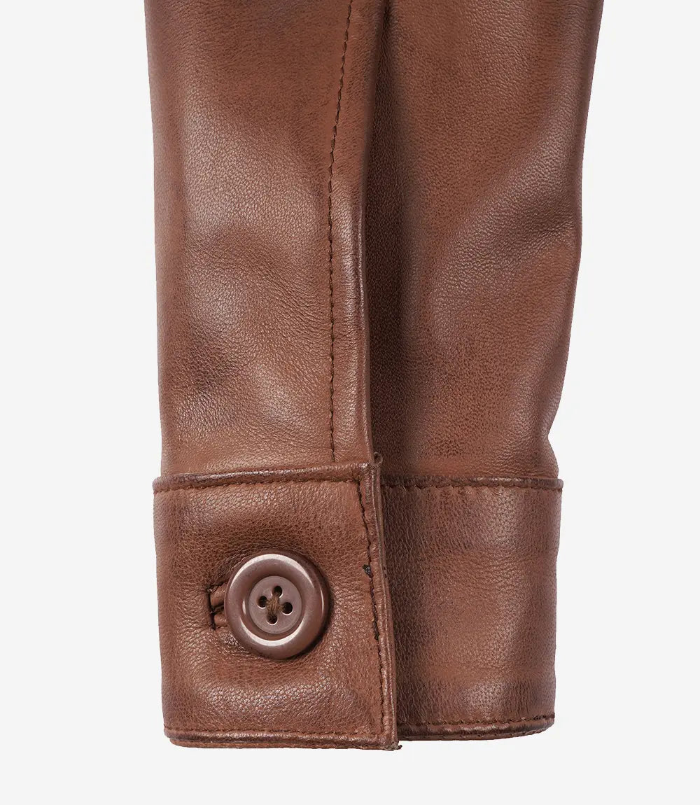 Close-up of Mila brown leather jacket showing a button cuff and sleeve stitching