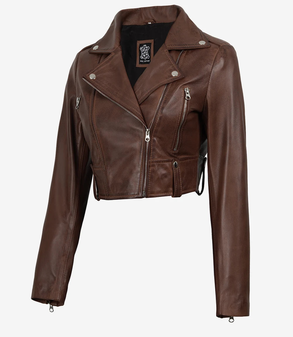 Rhea women's brown cropped leather biker jacket, angled front view showing zipped pocket and waist tab