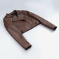 Rhea women's brown cropped leather biker jacket laid flat, showing long sleeves and asymmetric front zip