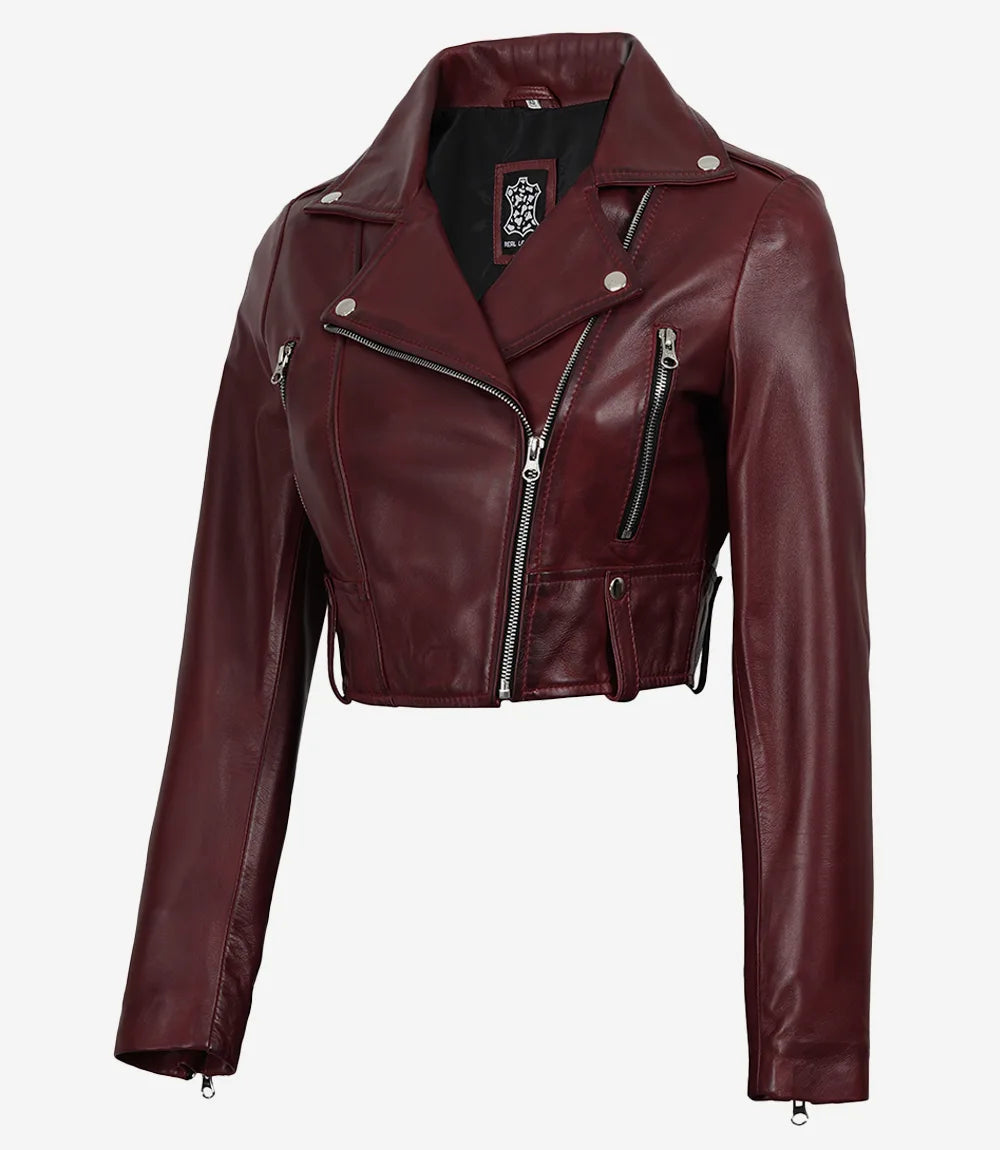 Rhea women's burgundy cropped leather biker jacket, angled front view showing zipped pocket and waist tab